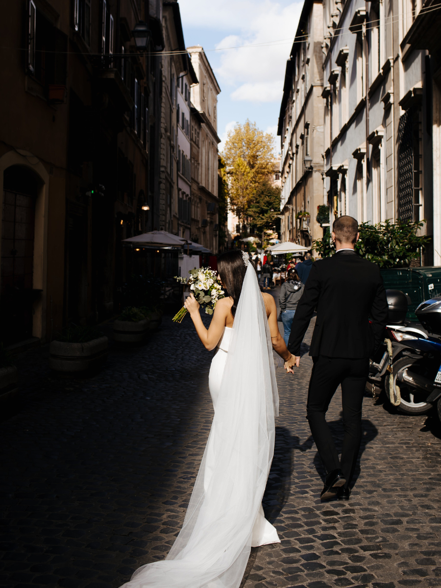 Newlyweds walking down cobblestone street after eloping