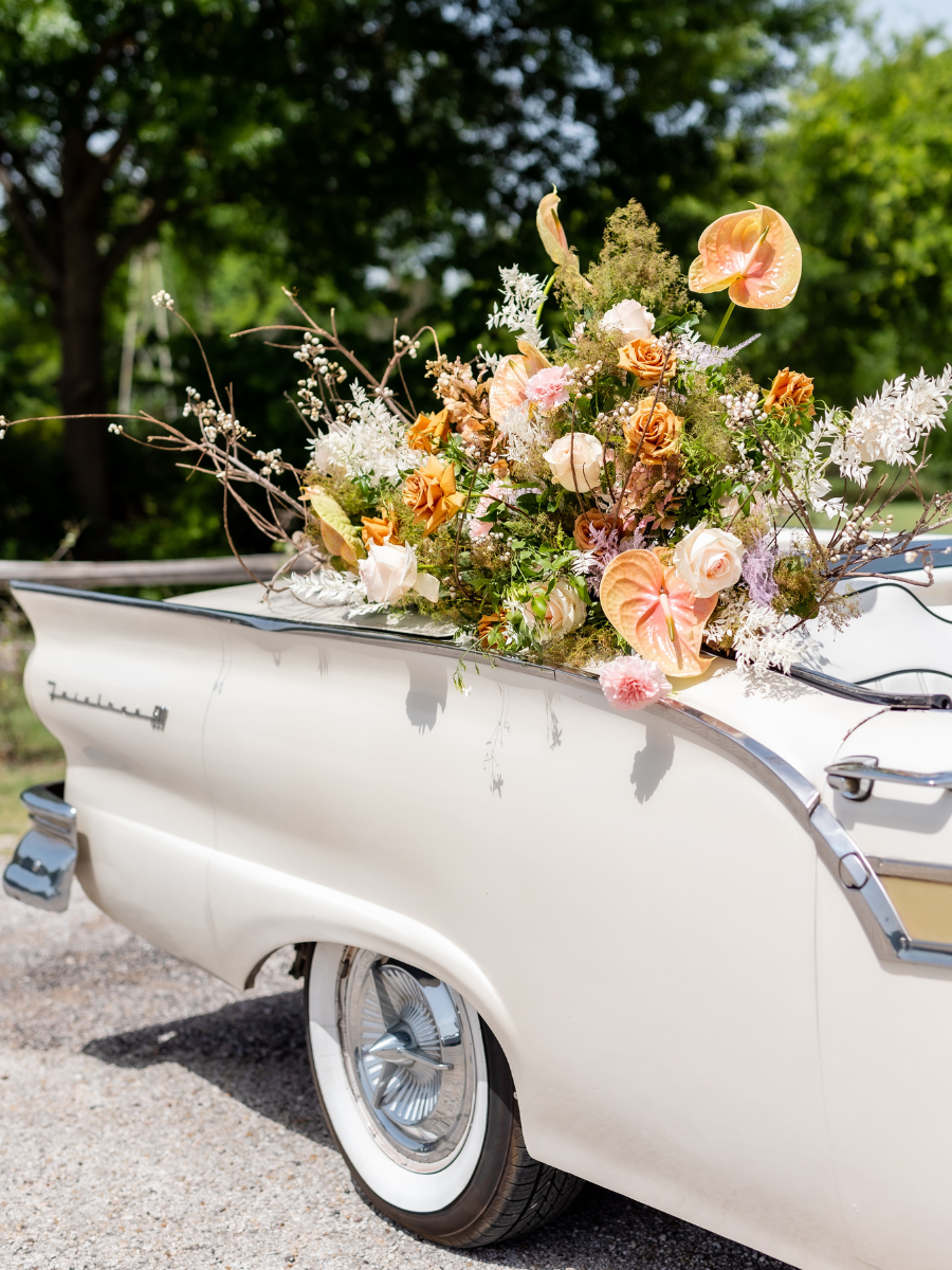 Bouquet of flowers in the trunk of a classic, white car